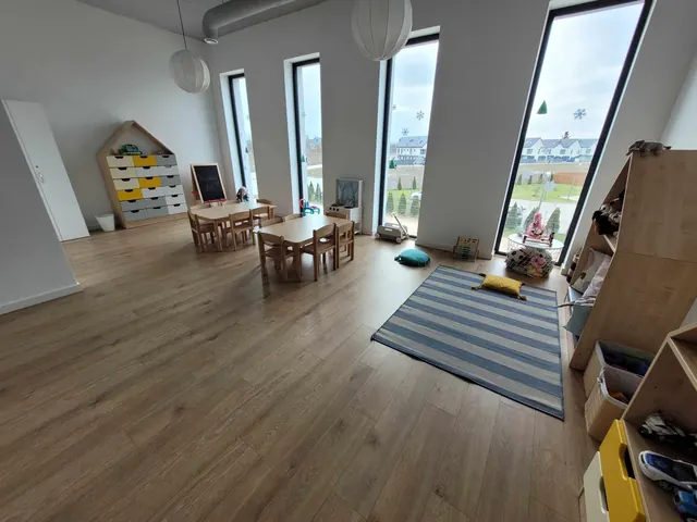 Sala z dużymi oknami, dywanem i kącikiem do czytania